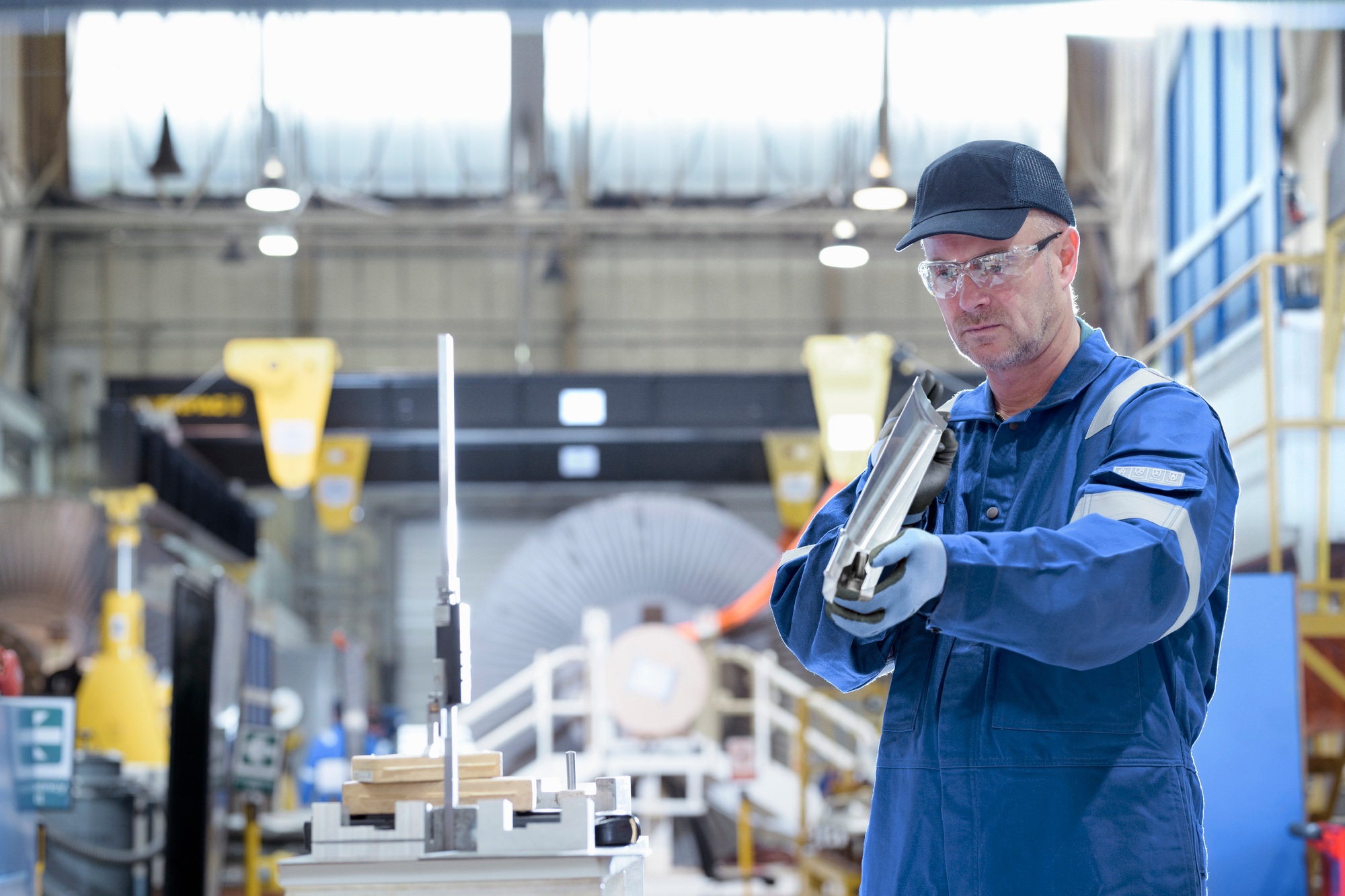 Engineer inspecting turbine blade in turbine maintenance factory
